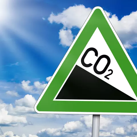 Straßenschild mit sinkendem CO2-Ausstoß