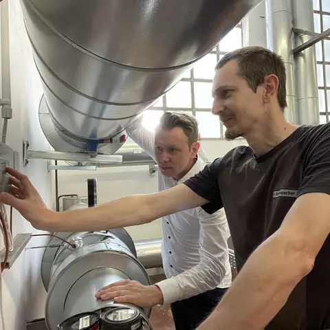 Two employees of the Schwabe Group at a heat meter.